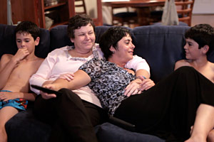 Filmstill GAYBY BABY, Matt mit seinen beiden lesbischen Müttern und seinem Bruder auf dem Sofa