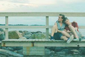 Film Still PIHALLA – SCREWED – AUF ZU NEUEN UFERN von Regisseur Nils-Erik Ekblom; der 17-jährige Miku (gespielt von Mikko Kauppila) sitzt an die Schulter seines Freunds Elias (gespielt von Valtteri Lehtinen) gelehnt auf einem Holzsteg am Strand