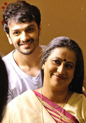Film Still EVENING SHADOWS von Regisseur, Produzent und Ko-Autor Sridhar Rangayan aus Indien, 2018; Kartik (gespielt von Devansh Doshi) steht hinter seiner Mutter Vasudha (gespielt von Mona Ambegaonkar) und sie lächeln sich an