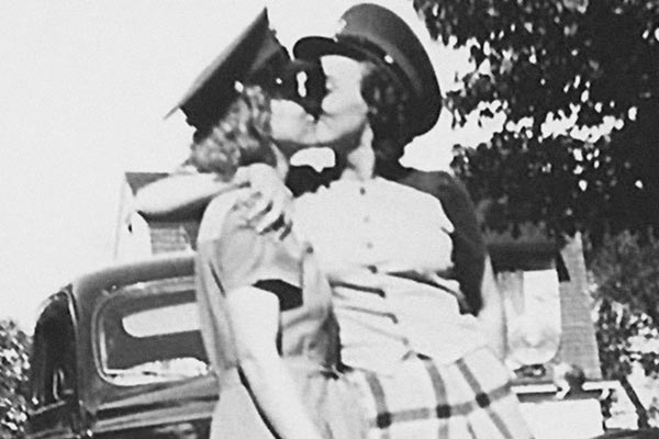 Film Still THE LAVENDER SCARE von Debüt-Regisseur Josh Howard aus USA, 2017, über Eisenhowers Hexenjagd auf homosexuelle US-Regierungsmitarbeiter; Silhuetten von zwei Frauen mit Schaffner-Kappen, die sich in den 1950ern vor einem Haus küssen